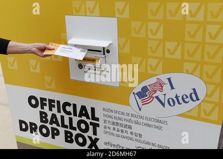 IRVINE, CALIFORNIA - 18 OTT 2020: Donna che mette la posta in un voto ufficiale Drop Box in Orange County, California. Foto Stock