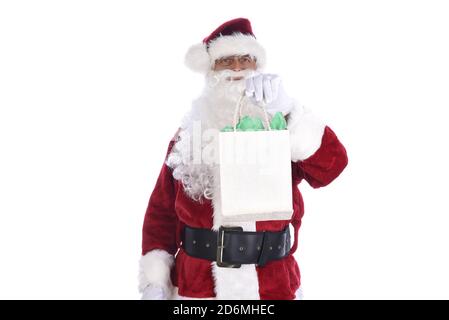 Uomo anziano che indossa un costume tradizionale di Sant Claus che tiene in mano una borsa da regalo. Isolato su bianco. Foto Stock