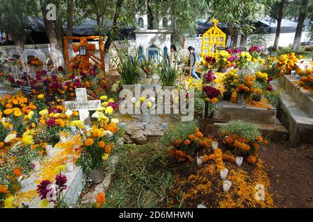 I marigolds conosciuti in Messico, come 'il fiore dei morti' decorano tombe a Patzcuaro durante il giorno dei morti, quando le famiglie ricordano i loro cari. Foto Stock