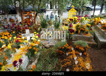 I marigolds conosciuti in Messico, come 'il fiore dei morti' decorano tombe a Patzcuaro durante il giorno dei morti, quando le famiglie ricordano i loro cari. Foto Stock