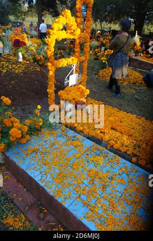 I marigolds conosciuti in Messico, come 'il fiore dei morti' decorano tombe a Patzcuaro durante il giorno dei morti, quando le famiglie ricordano i loro cari. Foto Stock