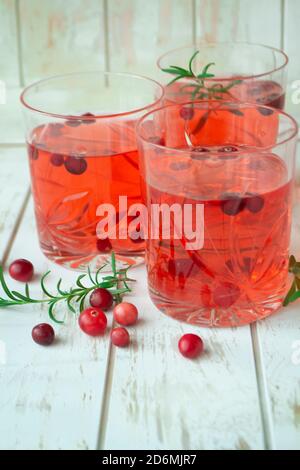 Bevanda fredda con mirtilli rossi in vetro su sfondo di legno chiaro traballante. Foto Stock