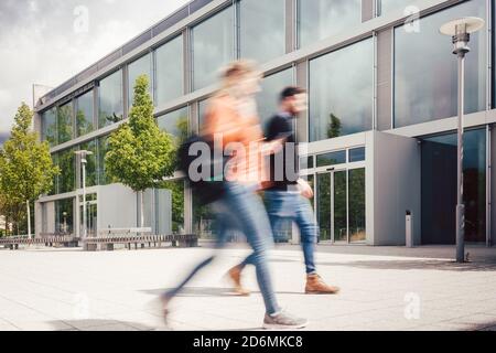 Silhouette sfocata degli studenti impegnati nel campus universitario Foto Stock