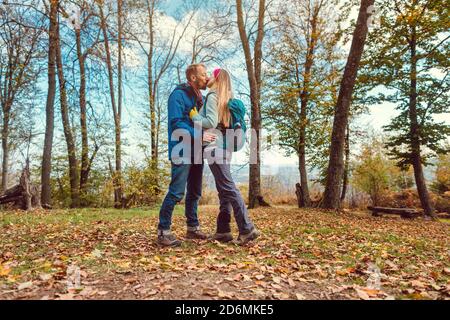 Coppia di uomini e donne che si baciano durante la passeggiata in autunno Foto Stock