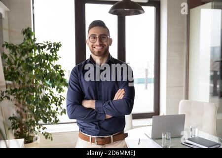 Ritratto di felice giovane uomo d'affari arabo in carica. Foto Stock