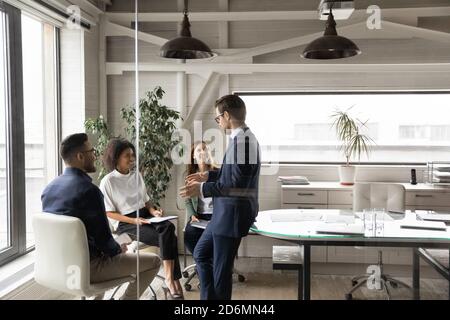 Felici i giovani compagni di squadra di gara misti che godono di tempo di pausa con il leader. Foto Stock