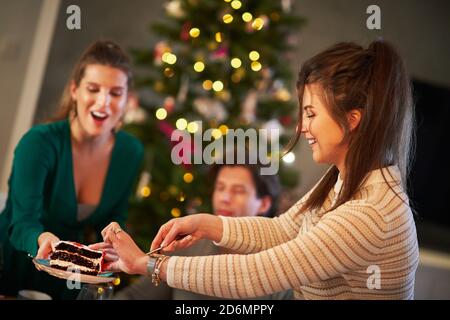 Gruppo di amici che festeggiano il Natale a casa Foto Stock