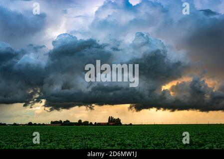Spettacolari nuvole tempeste su terreni agricoli al tramonto Foto Stock