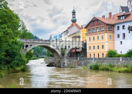 Ponte ad arco sul fiume Mur nella storica città di Murau, nelle Alpi centrali orientali, Austria Foto Stock