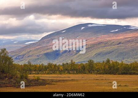 Montagna illuminata dal sole durante il tramonto in Vistas Valley, Kebnekaise montagne, Norrbotten, Svezia Foto Stock