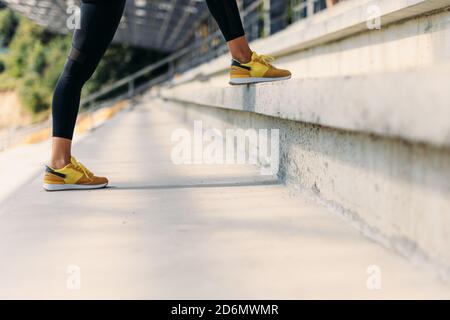 Primo piano delle gambe femminili nelle sneaker sportive in piedi scale Foto Stock