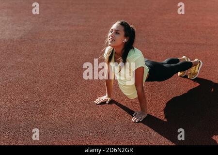 Bella donna sportiva facendo esercizi di stretching Foto Stock