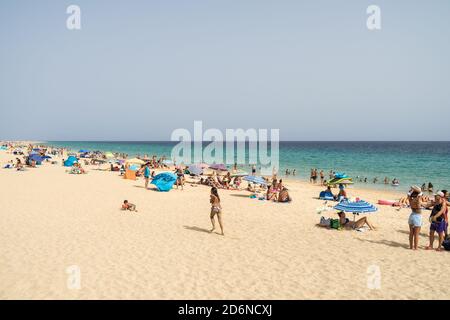 MORRO JABLE, FUERTEVENTURA, ISOLE CANARIE - 16 LUGLIO 2020: Poco affollata ma una volta popolare spiaggia di sabbia (Playa Morro Jable). Conseguenze del turismo in Foto Stock