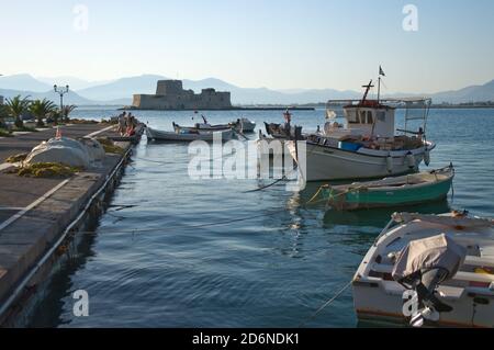 NAFPLIO, GRECIA - 10 LUGLIO 2009: Ormeggiata barca nella baia di Nauplion, sullo sfondo il castello di Bourtzi Foto Stock