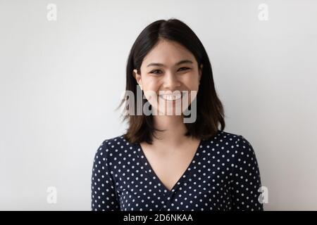 Ritratto di una donna asiatica sorridente isolata su una parete grigia Foto Stock