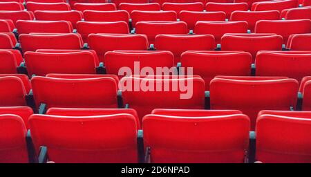 File di posti a sedere rossi per lo stadio Foto Stock