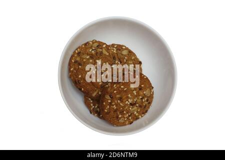 Accatastare alcuni biscotti di farinata d'avena con i cereali nel recipiente sfondo bianco isolato Foto Stock