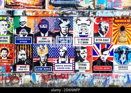 Poster politici su un muro coperto di graffiti, poster e opere d'arte di Brick Lane, East London, UK Foto Stock