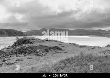 Loch Doon e le colline Galloway in lontananza con un cielo invernale brody. Foto Stock