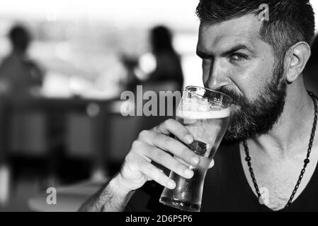 L'uomo brutale con il portacolori siede al bancone del bar. Birrerie e bar. Foto Stock