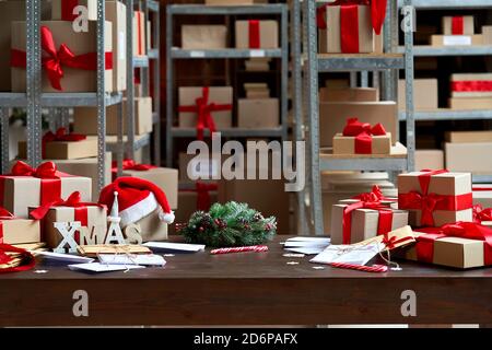 Tavolo di Natale decorato con scatole da regalo in sfondo interno magazzino. Foto Stock