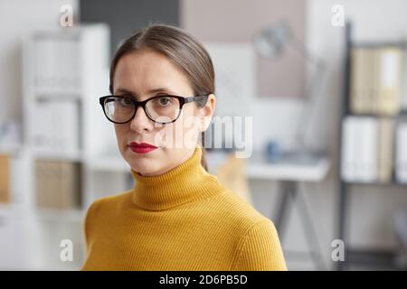Primo piano ritratto di donna adulta che indossa occhiali e guardando la fotocamera mentre si trova in ufficio architetti, copia spazio Foto Stock