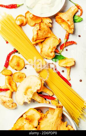 Ingredienti per cucinare la pasta con i finferli di funghi in una salsa cremosa, sfondo del cibo, vista dall'alto Foto Stock