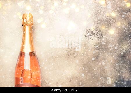 Bottiglia con spumante rosa o champagne rosato e bicchieri sotto la neve, concetto di festa o data, piatto, vista dall'alto Foto Stock