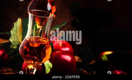 Bevanda alcolica d'oro forte francese di mele, sfondo di legno d'annata, fuoco selettivo Foto Stock