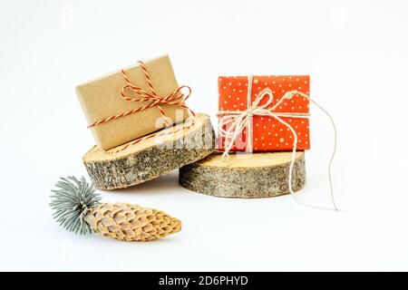 Due regali artigianali sui cilindri rotondi di legno forme sullo sfondo chiaro. Concept Natale e Capodanno. Foto Stock