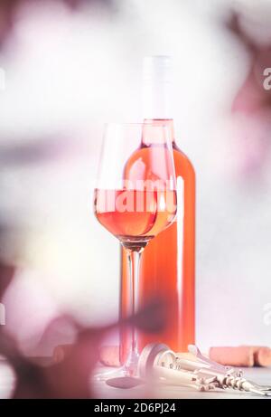 Bicchiere di vino rosato con bottiglia sul tavolo grigio. rosado rosa, rosato o degustazione di vini arrossati in wineshop, concetto bar. Copia spazio Foto Stock