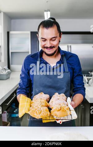 Uomo messicano cucina Pan de Muerto pane tradizionale per il giorno Dei morti in Messico Foto Stock