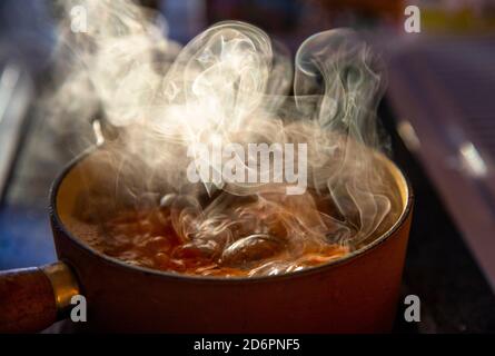 uova che bollono sulla stufa con vapore che sale Foto Stock