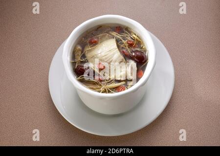 Zuppa cinese di pollo alle erbe servita in una ciotola Foto Stock