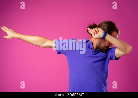 Uomo hipster in dab posa danza su sfondo rosa Foto Stock