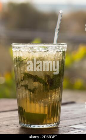 Bicchiere di Mojito, bevanda cubana al rum e un tavolo con paglia. Foto Stock