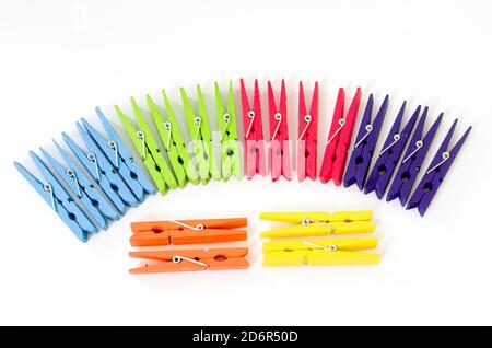 Assortimento di abiti da lavanderia in legno colorati o colorati Pegs on Uno sfondo bianco Foto Stock