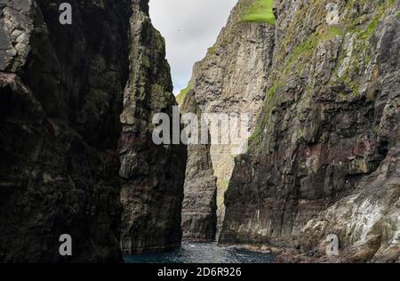 Le scogliere, le pile di mare e gli archi a Vestmanna, una delle grandi attrazioni delle Isole Faroe l'isola di Streymoy, una delle due grandi isole di Foto Stock