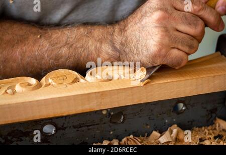 Carpentiere che lavora su mobili in legno con intaglio a mano. Scultura in legno con utensili a mano Foto Stock