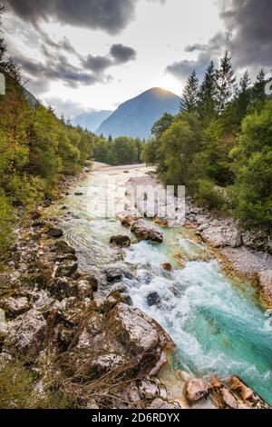 fiume soca con riva rocciosa e montagna sullo sfondo Foto Stock