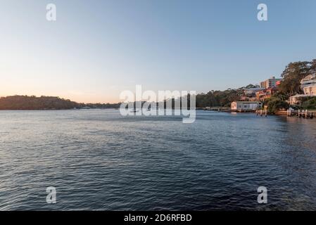 Le case sul bordo dell'acqua a Blues Bay nel porto di Sydney tardi In un pomeriggio di primavera soleggiato preso da McMahons Point Foto Stock