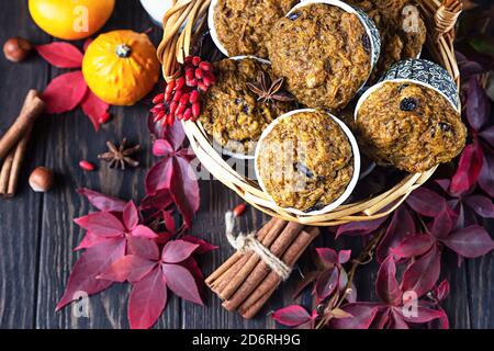 Muffin piccanti di zucca fatti in casa con noci e uvetta, zucche e spezie su sfondo rustico. Cottura in autunno e inverno. Foto Stock