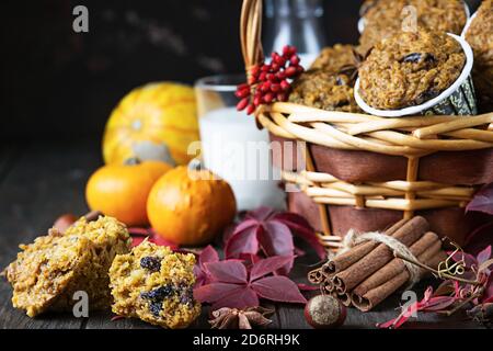 Muffin piccanti di zucca fatti in casa con noci e uvetta, zucche e spezie su sfondo rustico. Cottura in autunno e inverno. Foto Stock