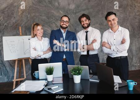 Team giovane di successo che guarda la telecamera. Team di startup aziendale concettuale amichevole Foto Stock