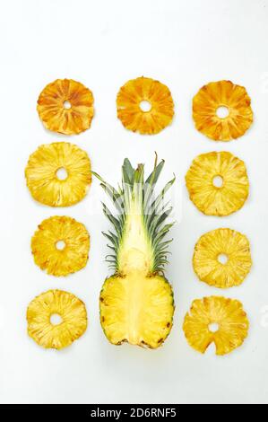 Composizione piatta con fette di ananas fresche e secche su fondo bianco. Foto Stock