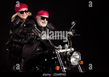 Foto di bikers anziani grigio capelli uomo donna coppia guida moto d'epoca in viaggio in pensione incontra le avventure indossano un rocker alla moda pantaloni da giacca in pelle Foto Stock