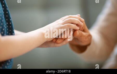 Nipote che sostiene la nonna. Le mani si avvicinano. Foto Stock