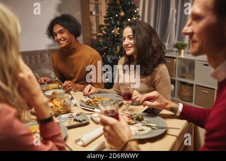 Ritratto della donna mediorientale adulta sorridente felice mentre si gusta la cena con amici e familiari al chiuso, spazio copia Foto Stock