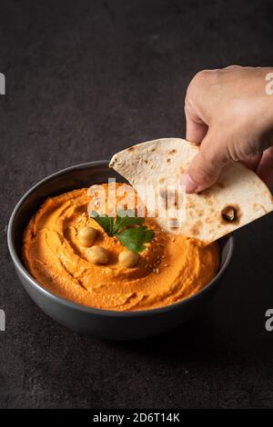 Hummus di zucca in ciotola su sfondo nero Foto Stock