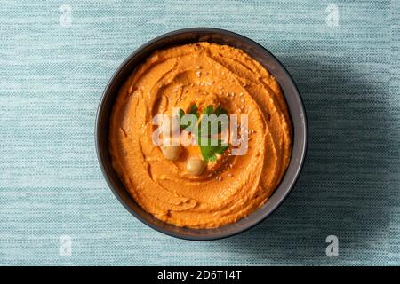 Hummus di zucca in ciotola su sfondo blu Foto Stock